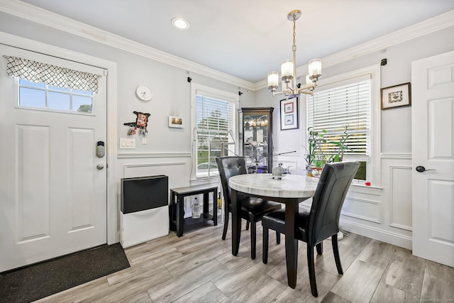 145 Arlington St, Bridgeport, CT 06606 - dining room with a chandelier, a decorative wall, ornamental molding, light wood finished floors, and wainscoting