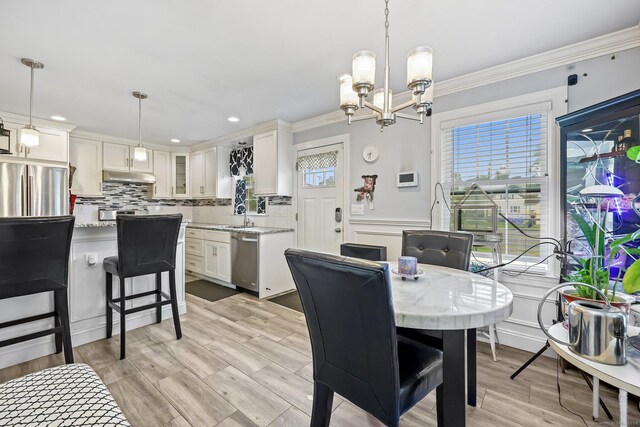 145 Arlington St, Bridgeport, CT 06606 - dining area with a chandelier, crown molding, a wainscoted wall, and recessed lighting