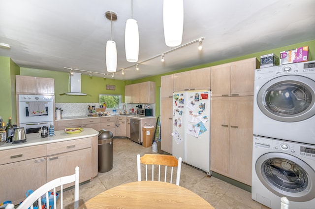 272 Saint John St, New Haven, CT 06511 - kitchen with stainless steel appliances, light brown cabinetry, estacked washer and dryer, wall chimney exhaust hood, and rail lighting