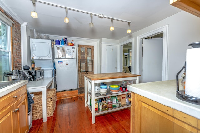 272 Saint John St, New Haven, CT 06511 - kitchen featuring freestanding refrigerator, stacked washer / dryer, dark wood-style flooring, and brown cabinets