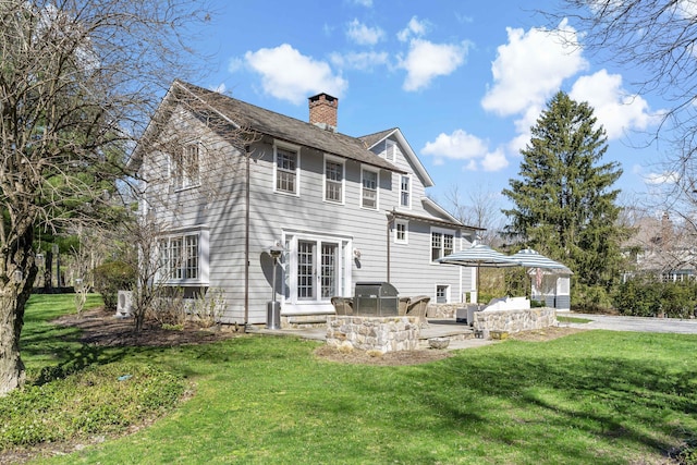 634 Nod Hill Rd, Wilton, CT 06897 - back of house with a chimney, a lawn, and a patio area