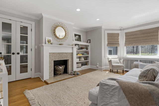 634 Nod Hill Rd, Wilton, CT 06897 - living room featuring french doors, wood finished floors, crown molding, a tiled fireplace, and recessed lighting