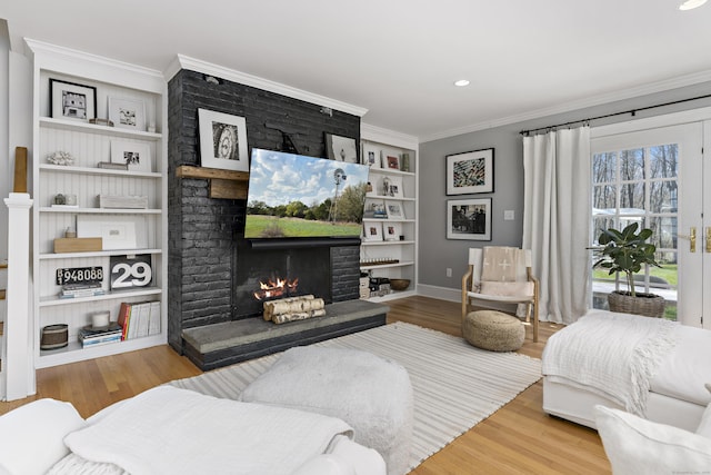 634 Nod Hill Rd, Wilton, CT 06897 - living room with a brick fireplace, ornamental molding, wood finished floors, built in shelves, and recessed lighting