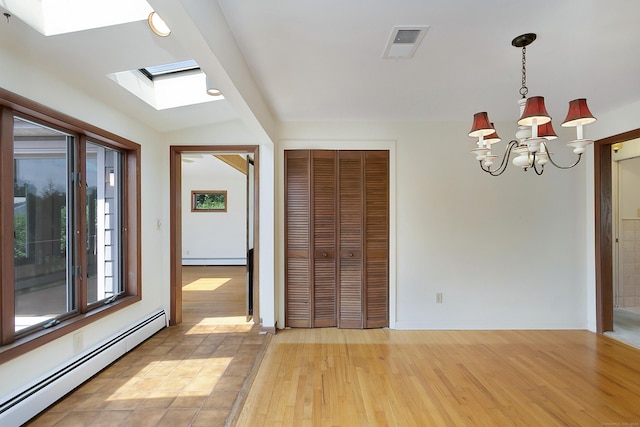 134 Millard St, Fairfield, CT 06824 - unfurnished room with baseboard heating, light wood finished floors, a chandelier, and a skylight
