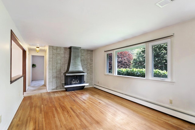 134 Millard St, Fairfield, CT 06824 - unfurnished living room with baseboard heating, wood finished floors, and a wood stove