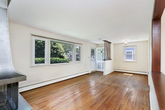 134 Millard St, Fairfield, CT 06824 - unfurnished living room featuring a baseboard heating unit, healthy amount of natural light, and wood finished floors