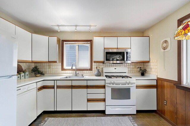 134 Millard St, Fairfield, CT 06824 - kitchen featuring white appliances, light countertops, white cabinetry, plenty of natural light, and wooden walls