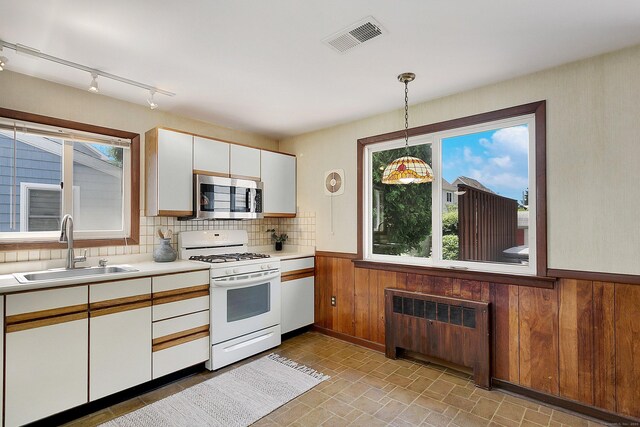 134 Millard St, Fairfield, CT 06824 - kitchen with white range with gas stovetop, stainless steel microwave, light countertops, plenty of natural light, and wainscoting