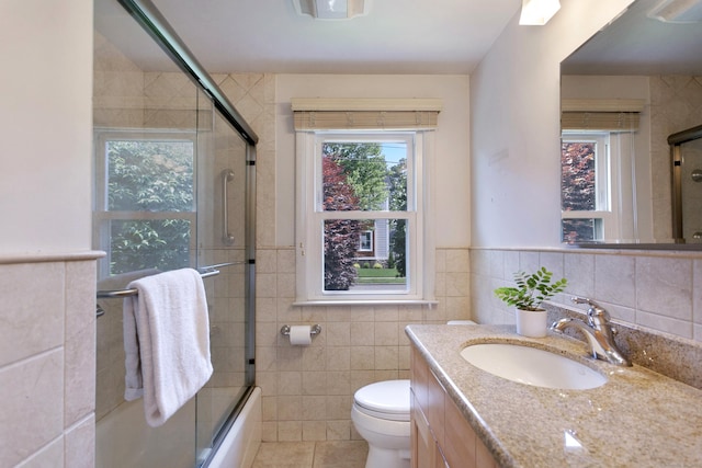 134 Millard St, Fairfield, CT 06824 - bathroom with tile walls, vanity, bath / shower combo with glass door, and tile patterned floors