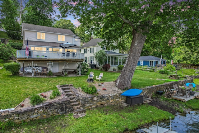 81 Standish Rd, Coventry, CT 06238 - rear view of house featuring a deck, an outdoor fire pit, a yard, a patio, and a sunroom