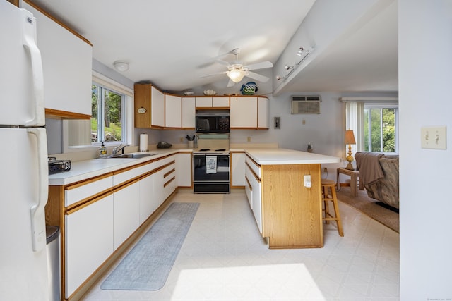 81 Standish Rd, Coventry, CT 06238 - kitchen with electric range, black microwave, freestanding refrigerator, a peninsula, and light flooring
