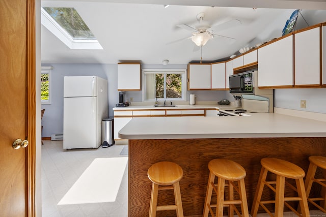81 Standish Rd, Coventry, CT 06238 - kitchen featuring freestanding refrigerator, black microwave, a baseboard radiator, range, and light countertops