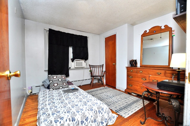 9 Eleanor Rd, Enfield, CT 06082 - bedroom featuring a baseboard heating unit, a textured ceiling, wood finished floors, and cooling unit