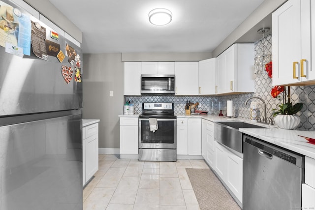 67 Woodside Cir Unit 67, Torrington, CT 06790 - kitchen with stainless steel appliances, tasteful backsplash, white cabinetry, and light tile patterned floors