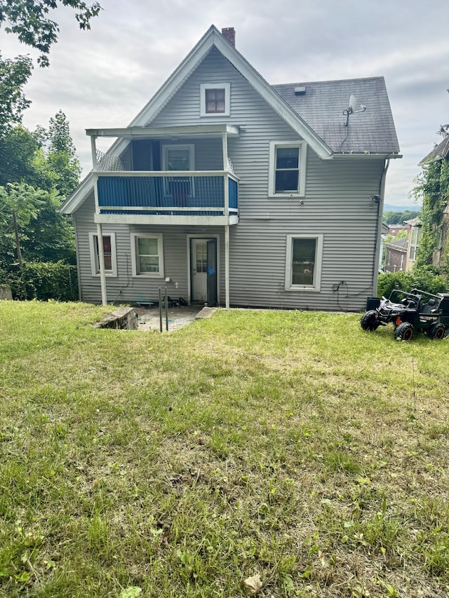 81 Easton Ave, Waterbury, CT 06704 - rear view of property featuring a yard, a chimney, a patio area, and a shingled roof