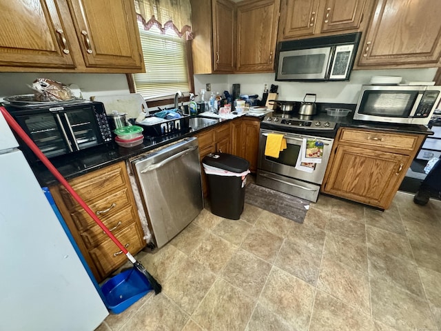 111 Hollywood Ave, Bridgeport, CT 06606 - kitchen with stainless steel appliances, brown cabinets, dark countertops, and stone finish floors