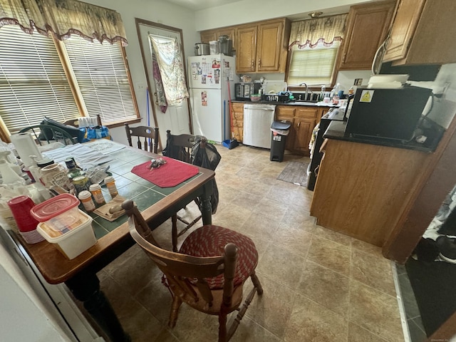 111 Hollywood Ave, Bridgeport, CT 06606 - kitchen featuring freestanding refrigerator, dishwasher, brown cabinetry, range, and dark countertops