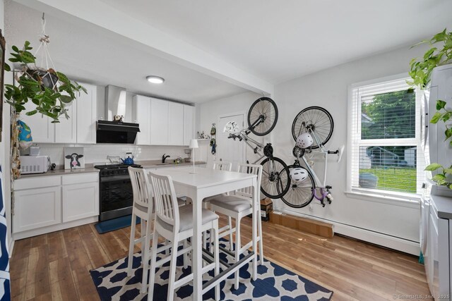 385 Blatchley Ave, New Haven, CT 06513 - kitchen featuring black gas stove, white microwave, backsplash, and wood finished floors