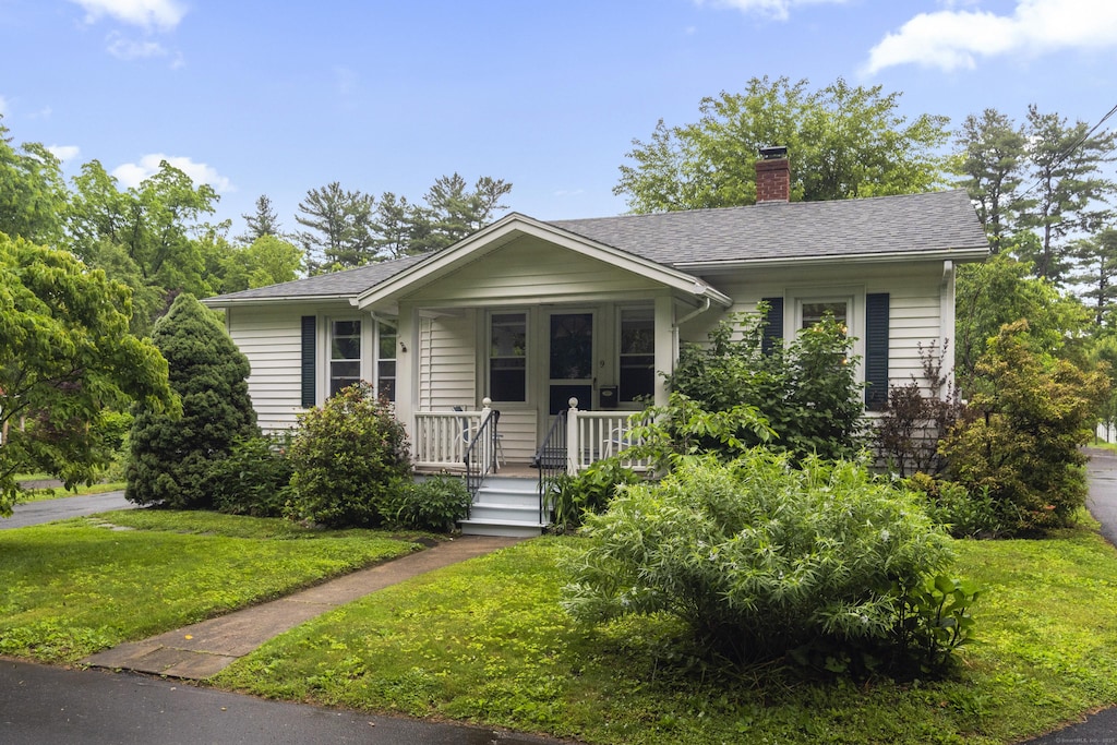 9 Carrington Ln, Farmington, CT 06032 - view of front facade featuring a porch, a chimney, a front lawn, and roof with shingles