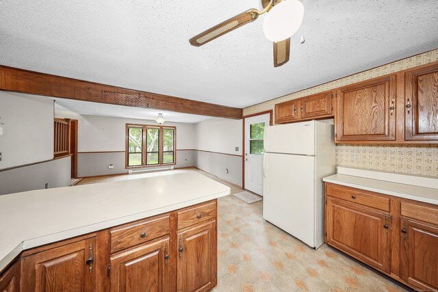 24 Cadbury Pl, Naugatuck, CT 06770 - kitchen with freestanding refrigerator, brown cabinetry, light floors, light countertops, and ceiling fan