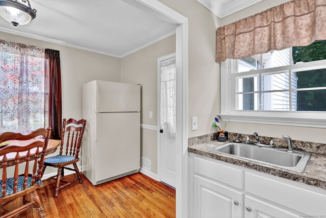 98 Morningside Dr W, Bristol, CT 06010 - kitchen featuring freestanding refrigerator, crown molding, light wood-type flooring, and white cabinetry
