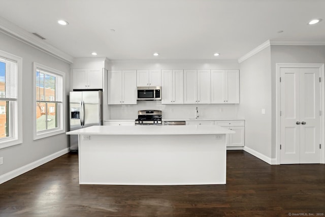 4 Armonk St, Greenwich, CT 06830 - kitchen featuring stainless steel appliances, crown molding, light countertops, dark wood-style floors, and a center island