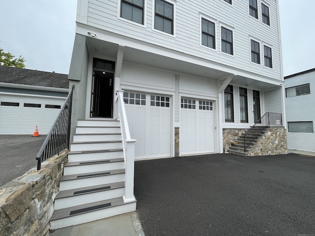 4 Armonk St, Greenwich, CT 06830 - view of front of house featuring an attached garage, asphalt driveway, and stairway