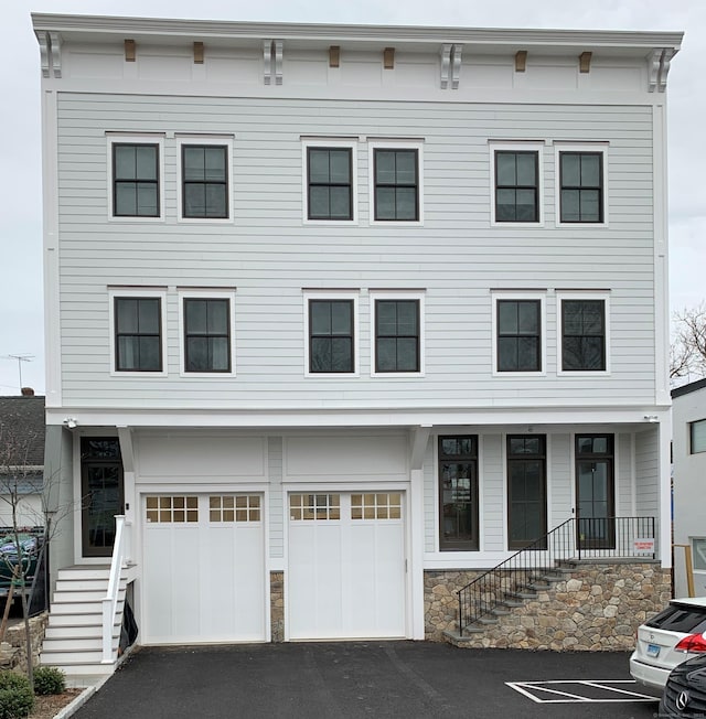 4 Armonk St, Greenwich, CT 06830 - townhome / multi-family property with an attached garage, stairs, driveway, and covered porch