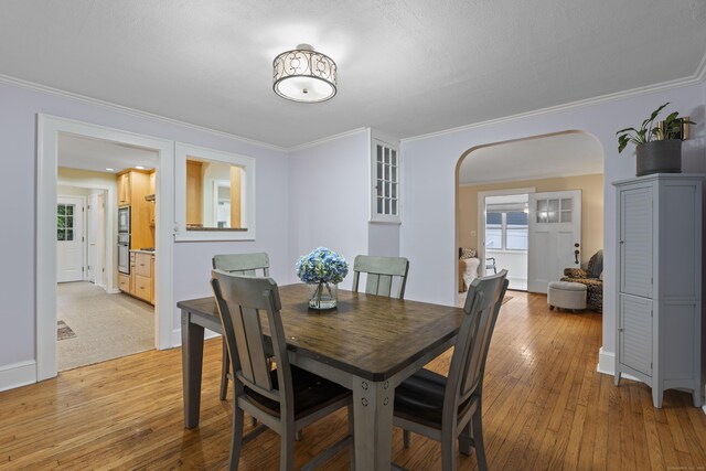51 Carmel St, Hamden, CT 06518 - dining room with arched walkways, crown molding, and light wood finished floors