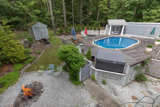 328 Old Marlborough Tpke, Portland, CT 06480 - view of swimming pool featuring a wooden deck, a hot tub, a storage unit, and a view of trees
