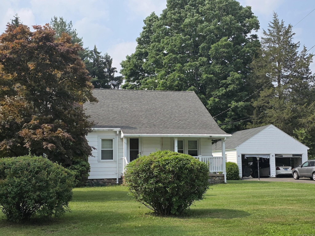 55 Defashion St, Southington, CT 06479 - view of front of house featuring an outdoor structure, covered porch, a garage, a front lawn, and a shingled roof