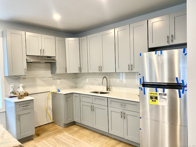 218 Charles St, Waterbury, CT 06708 - kitchen featuring freestanding refrigerator, gray cabinetry, under cabinet range hood, and light countertops