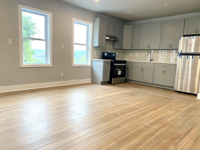 218 Charles St, Waterbury, CT 06708 - kitchen featuring stainless steel appliances, under cabinet range hood, gray cabinetry, light countertops, and tasteful backsplash