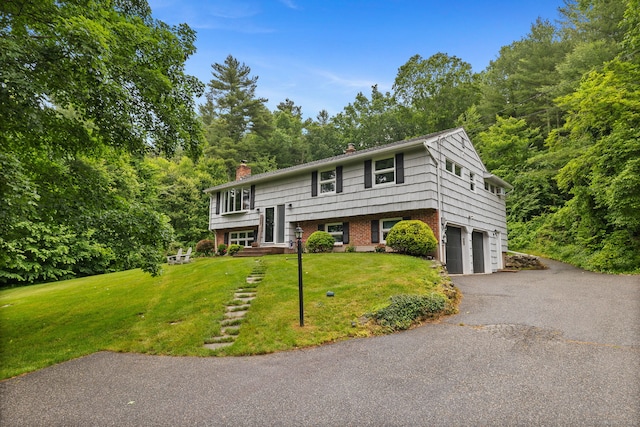 325 S Main St, Marlborough, CT 06447 - bi-level home with a chimney, a garage, a front lawn, and driveway