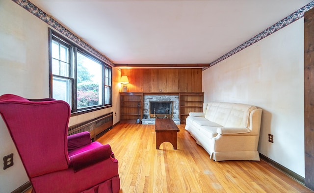 3 Fairview Hts, Cromwell, CT 06416 - living room featuring radiator, wood finished floors, a stone fireplace, and wood walls