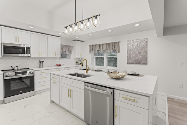 45 Westledge Rd, Simsbury, CT 06092 - kitchen featuring stainless steel appliances, recessed lighting, white cabinetry, light marble finish flooring, and an island with sink