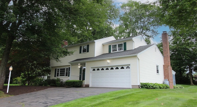 154 Sandy Ln, Meriden, CT 06450 - traditional home with asphalt driveway, a chimney, a garage, and a front lawn