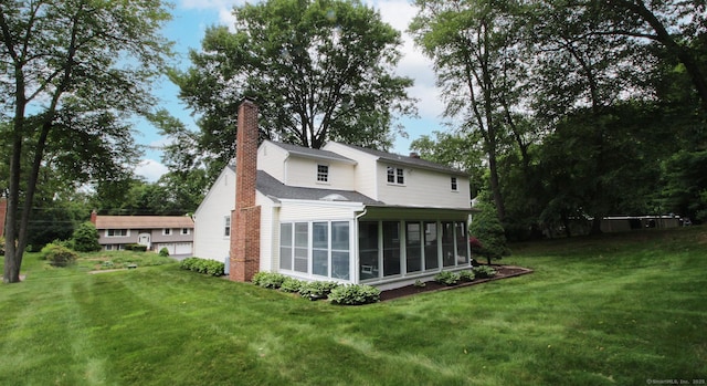 154 Sandy Ln, Meriden, CT 06450 - back of property featuring a sunroom, a chimney, and a lawn