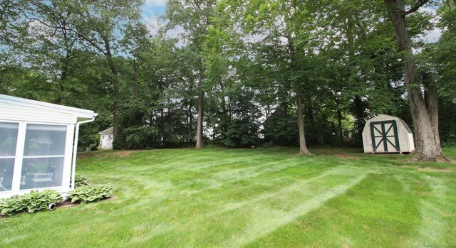 154 Sandy Ln, Meriden, CT 06450 - view of grassy yard with a storage unit and view of wooded area