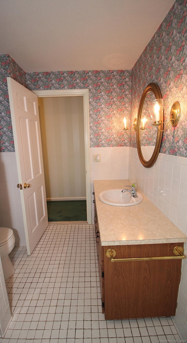 154 Sandy Ln, Meriden, CT 06450 - bathroom with wallpapered walls, a wainscoted wall, vanity, tile patterned floors, and tile walls