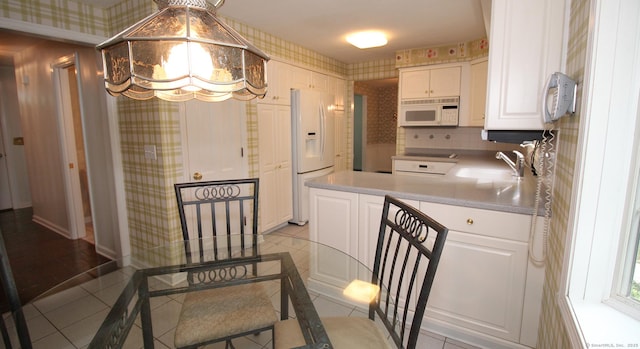 154 Sandy Ln, Meriden, CT 06450 - kitchen featuring white appliances, wallpapered walls, white cabinets, light tile patterned floors, and a peninsula