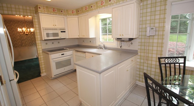 154 Sandy Ln, Meriden, CT 06450 - kitchen with wallpapered walls, white appliances, a chandelier, and white cabinets