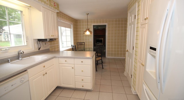 154 Sandy Ln, Meriden, CT 06450 - kitchen with white appliances, wallpapered walls, light tile patterned floors, a peninsula, and healthy amount of natural light
