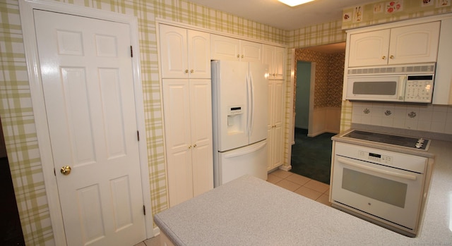 154 Sandy Ln, Meriden, CT 06450 - kitchen with white appliances, wallpapered walls, light tile patterned flooring, and white cabinetry