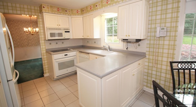 154 Sandy Ln, Meriden, CT 06450 - kitchen featuring white appliances, wallpapered walls, a chandelier, white cabinetry, and light tile patterned flooring