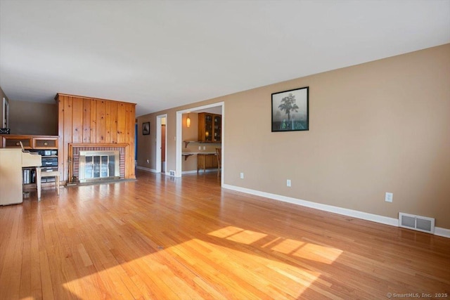 60 Ranch Rd, Milford, CT 06460 - unfurnished living room featuring light wood finished floors and a brick fireplace