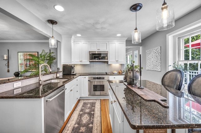 31 Country Way, Madison, CT 06443 - kitchen featuring appliances with stainless steel finishes, light wood finished floors, healthy amount of natural light, white cabinets, and recessed lighting
