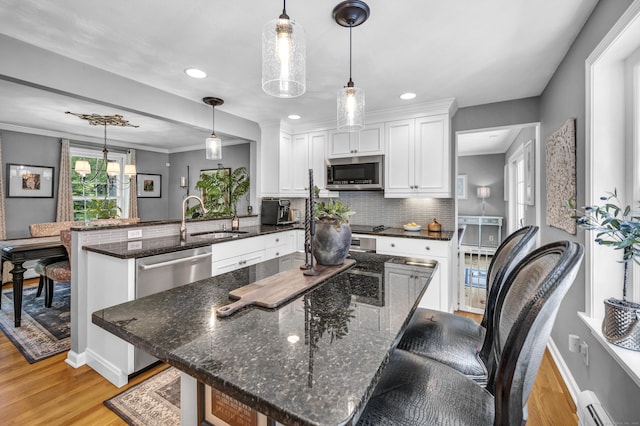31 Country Way, Madison, CT 06443 - kitchen featuring appliances with stainless steel finishes, a peninsula, light wood-style floors, white cabinetry, and recessed lighting