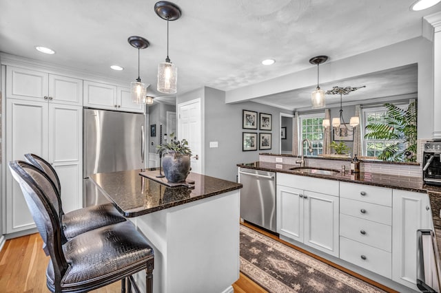 31 Country Way, Madison, CT 06443 - kitchen with stainless steel appliances, white cabinets, dark stone countertops, a peninsula, and light wood-style floors