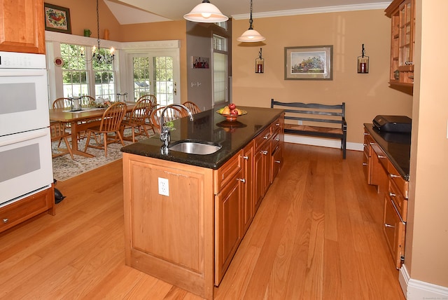 16 Brookfield Dr, Ellington, CT 06029 - kitchen with white double oven, light wood finished floors, a kitchen island with sink, crown molding, and dark stone counters